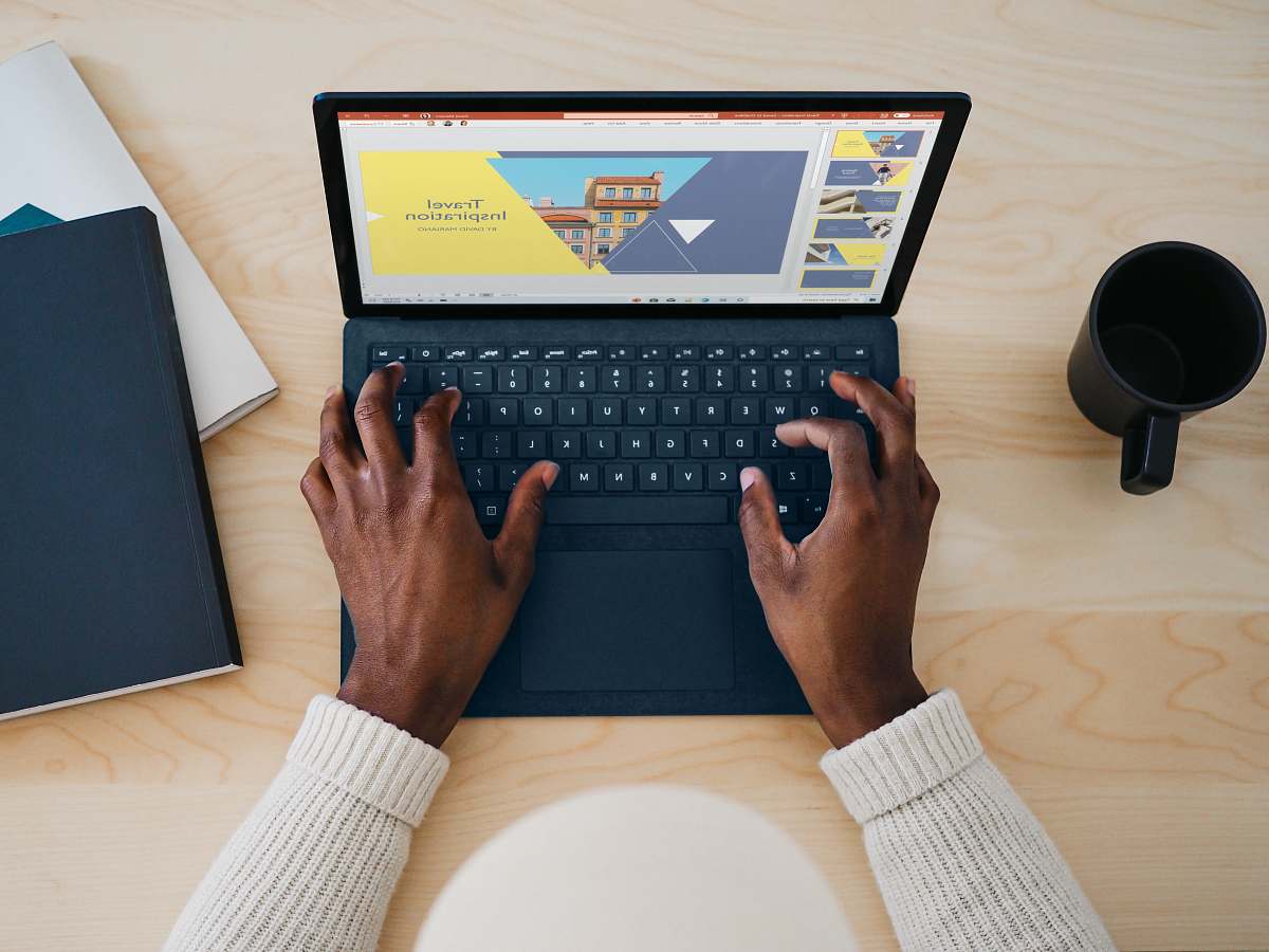 computer hardware person using cobalt blue microsoft surface laptop computer on a table  computer keyboard